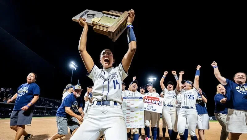 Enterprise pitcher Lauren Ramos (14) holds up the championship trophy as she and her teammates celebrate after defeating San Juan 7-4 in the 2A softball state championship game, held at Gail Miller Field in Provo on Saturday, May 9, 2026.