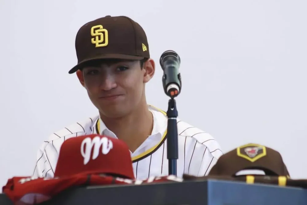 Humberto Cruz, a Mexican pitcher from Diablos Rojos del Mexico, appears in front of a microphone in San Diego Padres gear.